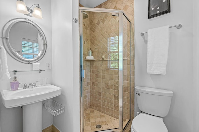 bathroom with toilet and a shower with door