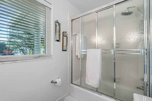 bathroom featuring bath / shower combo with glass door