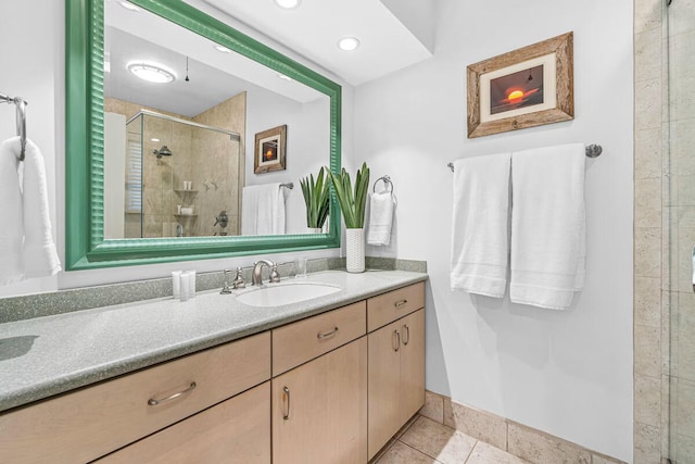 bathroom featuring tile patterned floors, vanity, and a shower with shower door