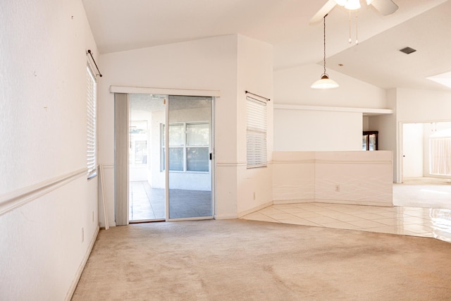 carpeted spare room featuring vaulted ceiling and ceiling fan