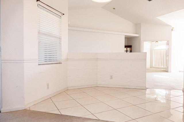 tiled spare room with lofted ceiling