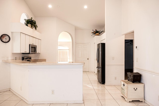 kitchen featuring kitchen peninsula, white cabinetry, light tile patterned floors, and appliances with stainless steel finishes