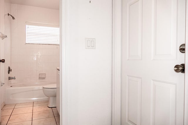 bathroom featuring tile patterned floors, tiled shower / bath combo, and toilet