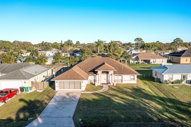 view of front facade with cooling unit, a front yard, and a garage