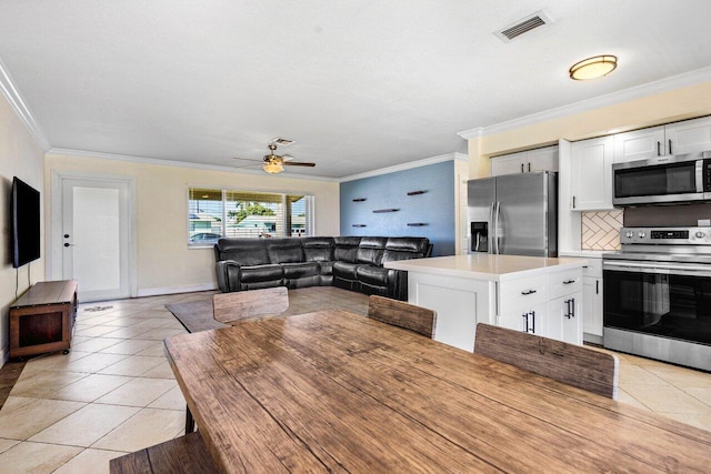 dining room featuring light tile patterned flooring, crown molding, visible vents, and a ceiling fan