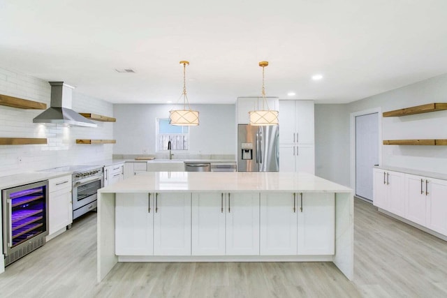 kitchen with white cabinets, beverage cooler, wall chimney exhaust hood, and appliances with stainless steel finishes