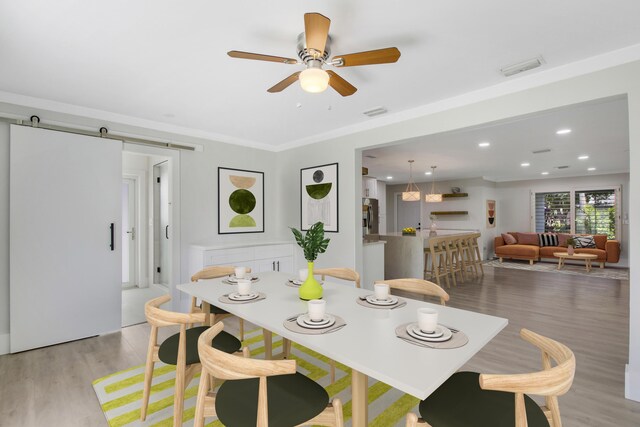 kitchen featuring appliances with stainless steel finishes, tasteful backsplash, wall chimney range hood, white cabinets, and hanging light fixtures