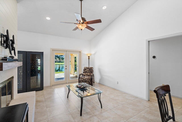 tiled living room featuring high vaulted ceiling, ceiling fan, and french doors