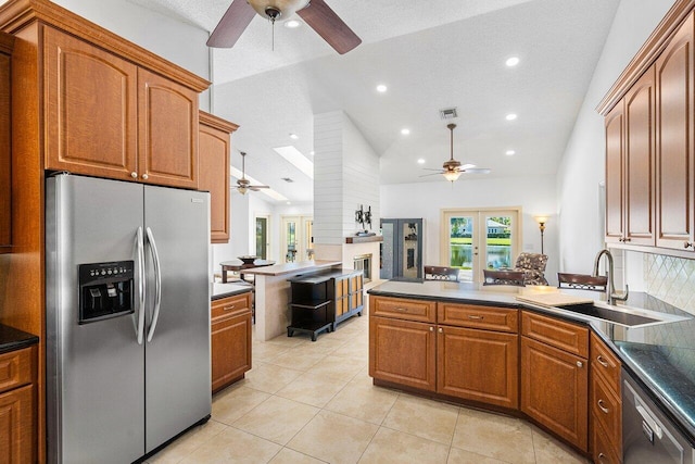 kitchen featuring stainless steel appliances, light tile patterned floors, french doors, sink, and tasteful backsplash