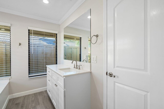 bathroom with vanity, ornamental molding, and hardwood / wood-style flooring