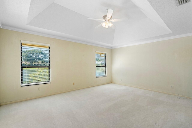 carpeted empty room with a textured ceiling, ceiling fan, a tray ceiling, and crown molding