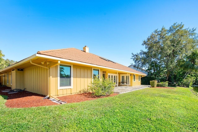 rear view of house featuring a patio area and a yard