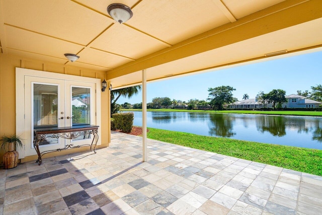 view of patio featuring french doors, ceiling fan, and a water view