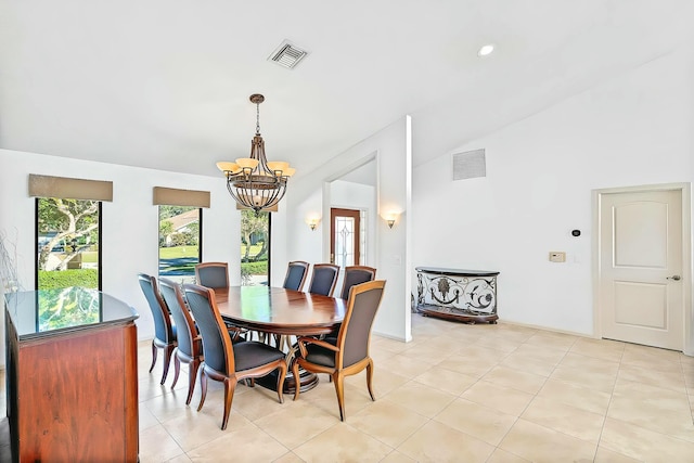 tiled dining room featuring an inviting chandelier and vaulted ceiling