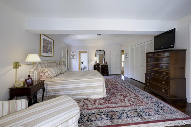 bedroom with dark hardwood / wood-style floors and a closet