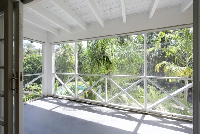 unfurnished sunroom featuring beam ceiling