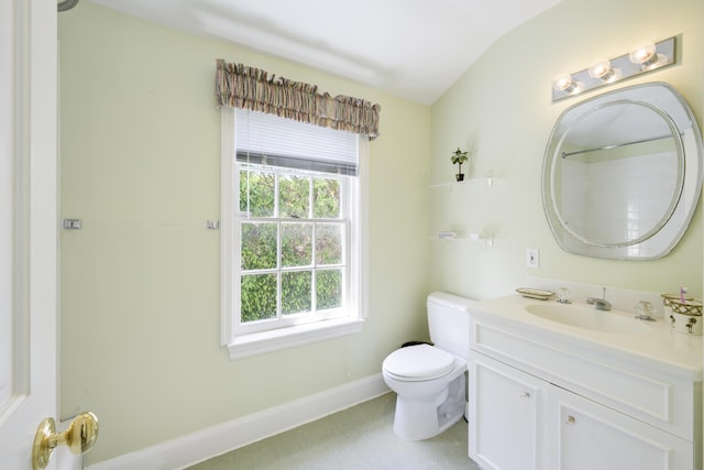 bathroom featuring vanity, toilet, and vaulted ceiling