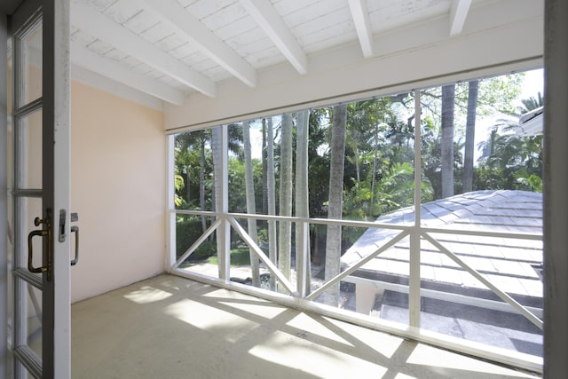 unfurnished sunroom with beamed ceiling, a healthy amount of sunlight, and wooden ceiling