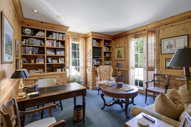 carpeted home office with wood walls