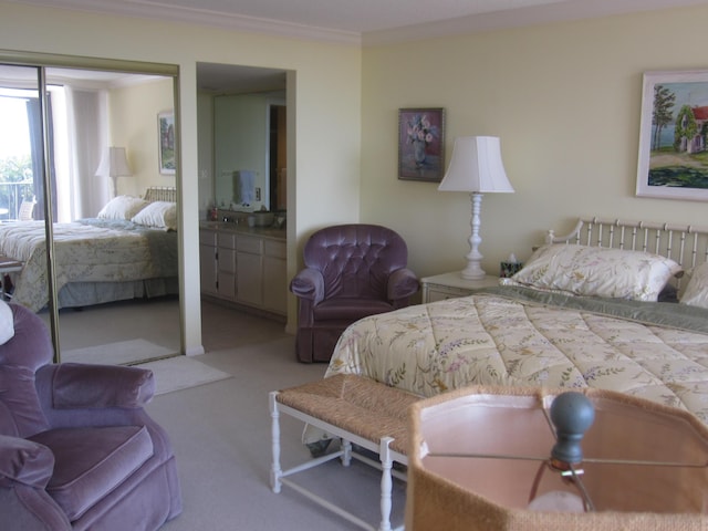 carpeted bedroom featuring connected bathroom and ornamental molding