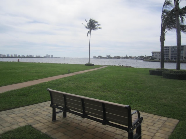 surrounding community with a patio area, a water view, and a yard