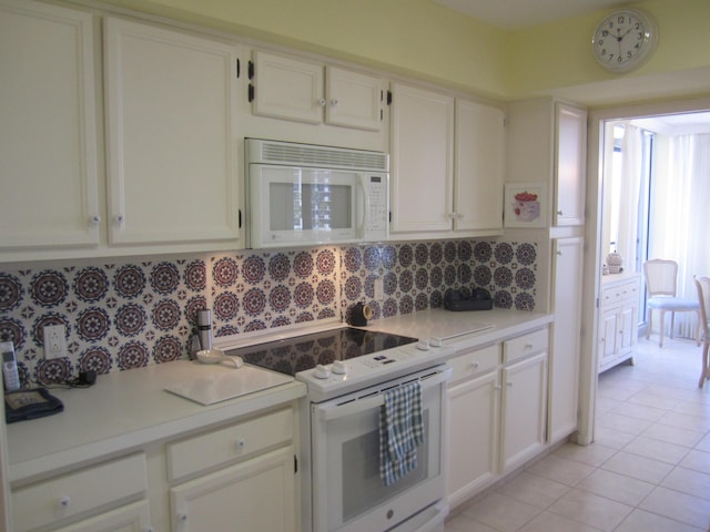 kitchen with white appliances, tasteful backsplash, white cabinetry, and light tile patterned flooring