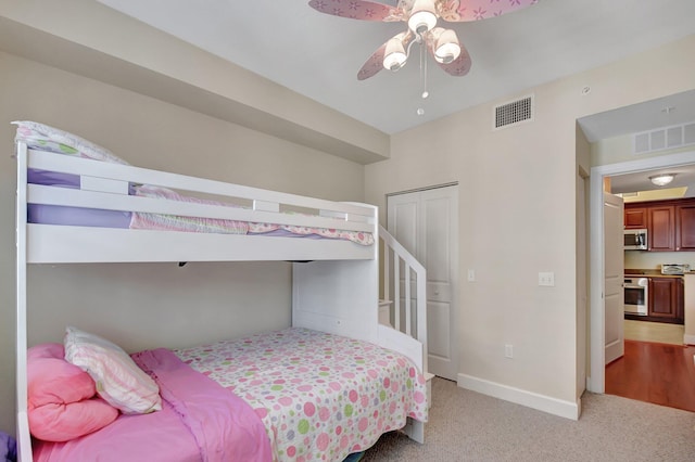 carpeted bedroom with ceiling fan and a closet