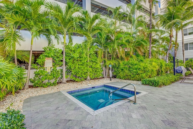 view of swimming pool featuring a patio and a hot tub