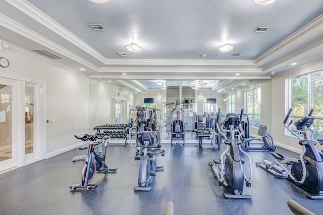 gym featuring a tray ceiling and ornamental molding