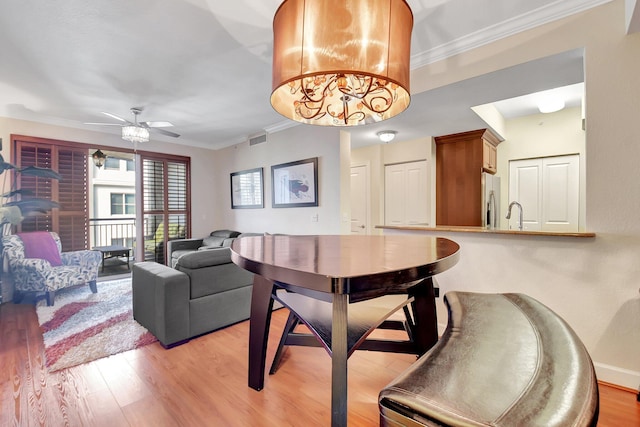 dining area with ceiling fan, crown molding, light hardwood / wood-style floors, and sink