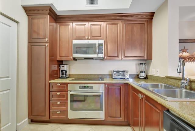 kitchen with light tile patterned floors, sink, and black appliances