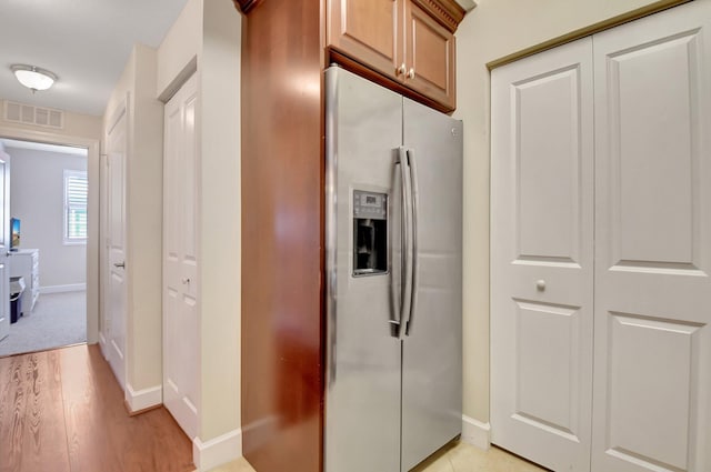 kitchen with stainless steel fridge and light hardwood / wood-style flooring