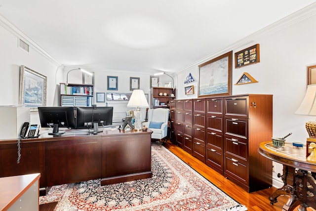 home office with light hardwood / wood-style floors and ornamental molding