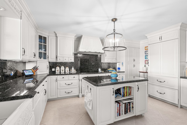 kitchen featuring pendant lighting, custom exhaust hood, a center island, and white cabinetry