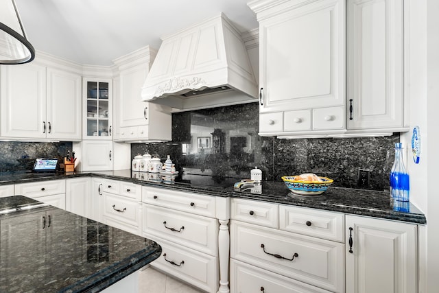 kitchen with white cabinets, decorative backsplash, black cooktop, and custom exhaust hood