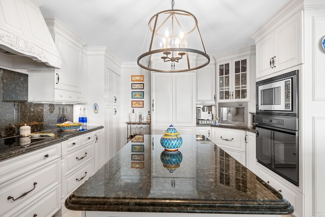 kitchen with white cabinets, oven, dark stone countertops, and custom range hood