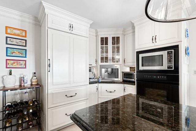 kitchen featuring white cabinets, black oven, built in microwave, and dark stone countertops