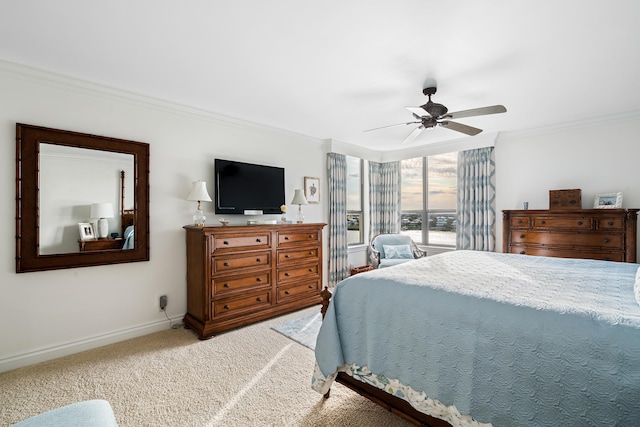 carpeted bedroom featuring ceiling fan and crown molding