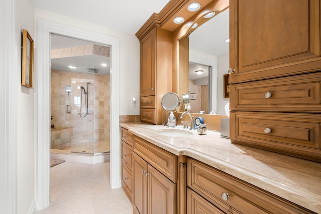 bathroom with a shower with door, vanity, and tile patterned flooring