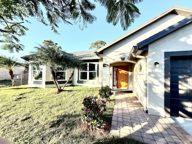 entrance to property featuring a lawn and a garage