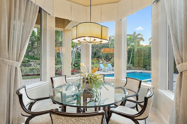 sunroom / solarium featuring a wealth of natural light and a chandelier