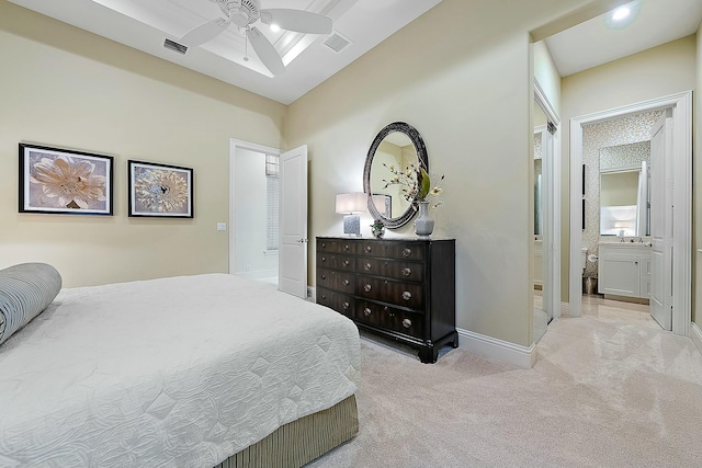 bedroom with ensuite bathroom, vaulted ceiling, light colored carpet, and ceiling fan