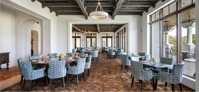 dining space with beam ceiling and dark parquet floors