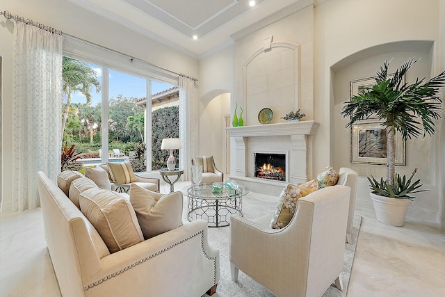 living room featuring a towering ceiling, ornamental molding, and a premium fireplace