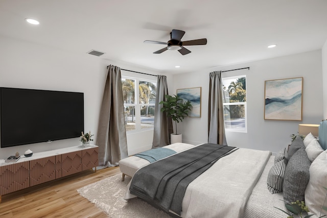 bedroom with ceiling fan, light wood-type flooring, and multiple windows