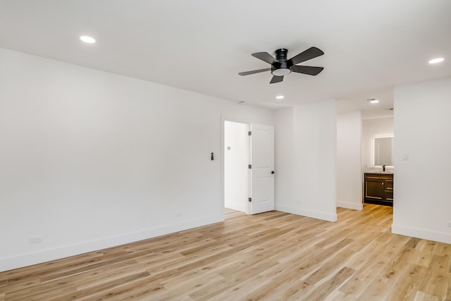 unfurnished room featuring light hardwood / wood-style floors, ceiling fan, and sink