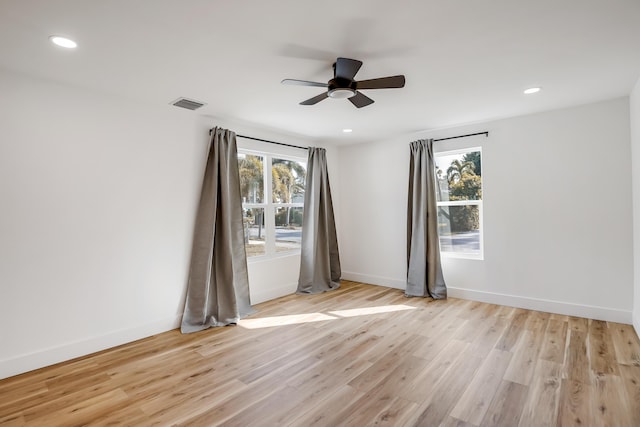 empty room with light wood-type flooring, a wealth of natural light, and ceiling fan