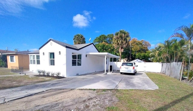 back of house with a carport and a lawn