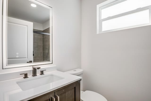 bathroom featuring vanity, toilet, and walk in shower