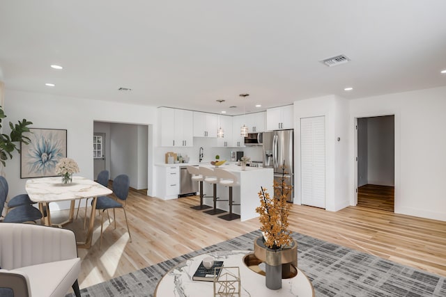 living room with light hardwood / wood-style flooring and sink